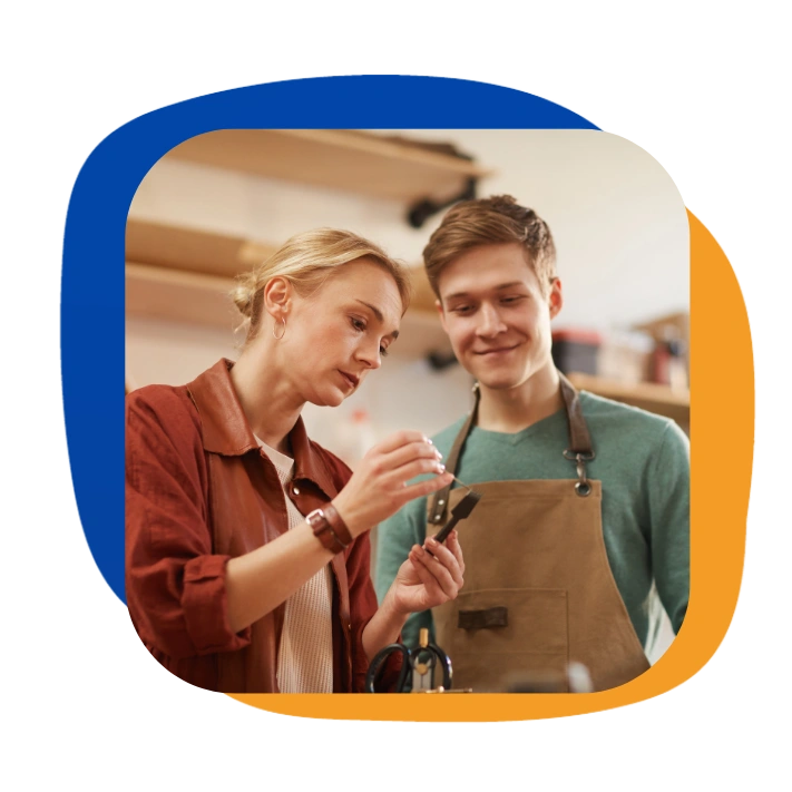 Family business owner mentoring a young apprentice, representing training and skills transfer in European SMEs